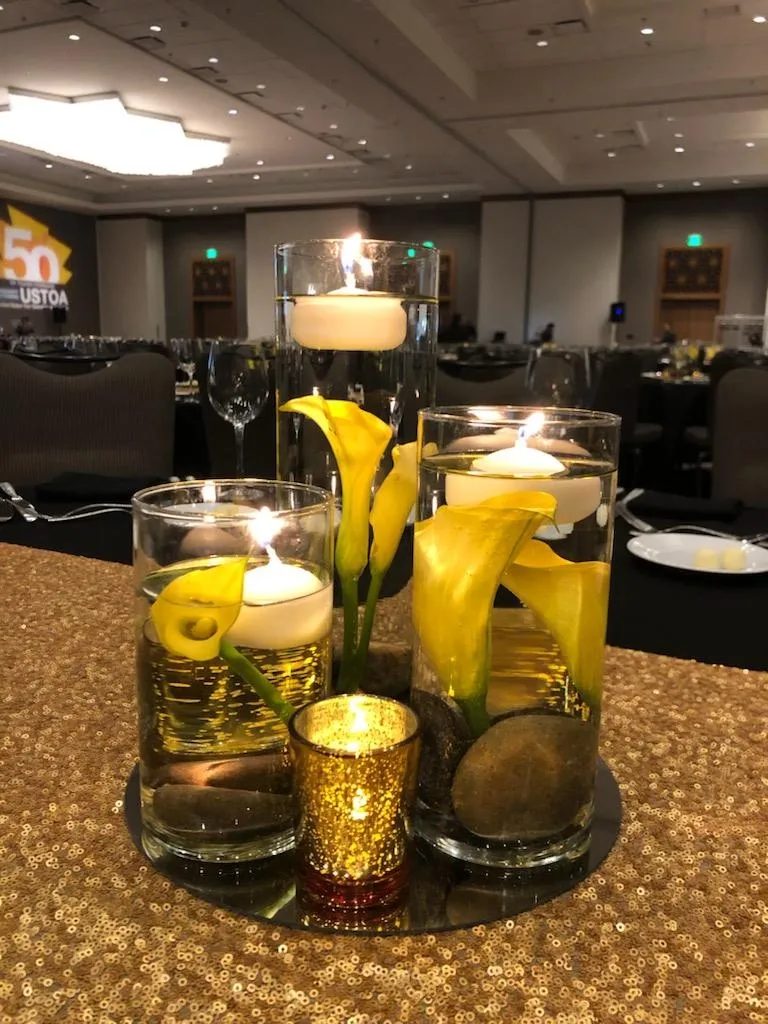 Floating calla lily centerpieces with candlelight at a corporate dinner