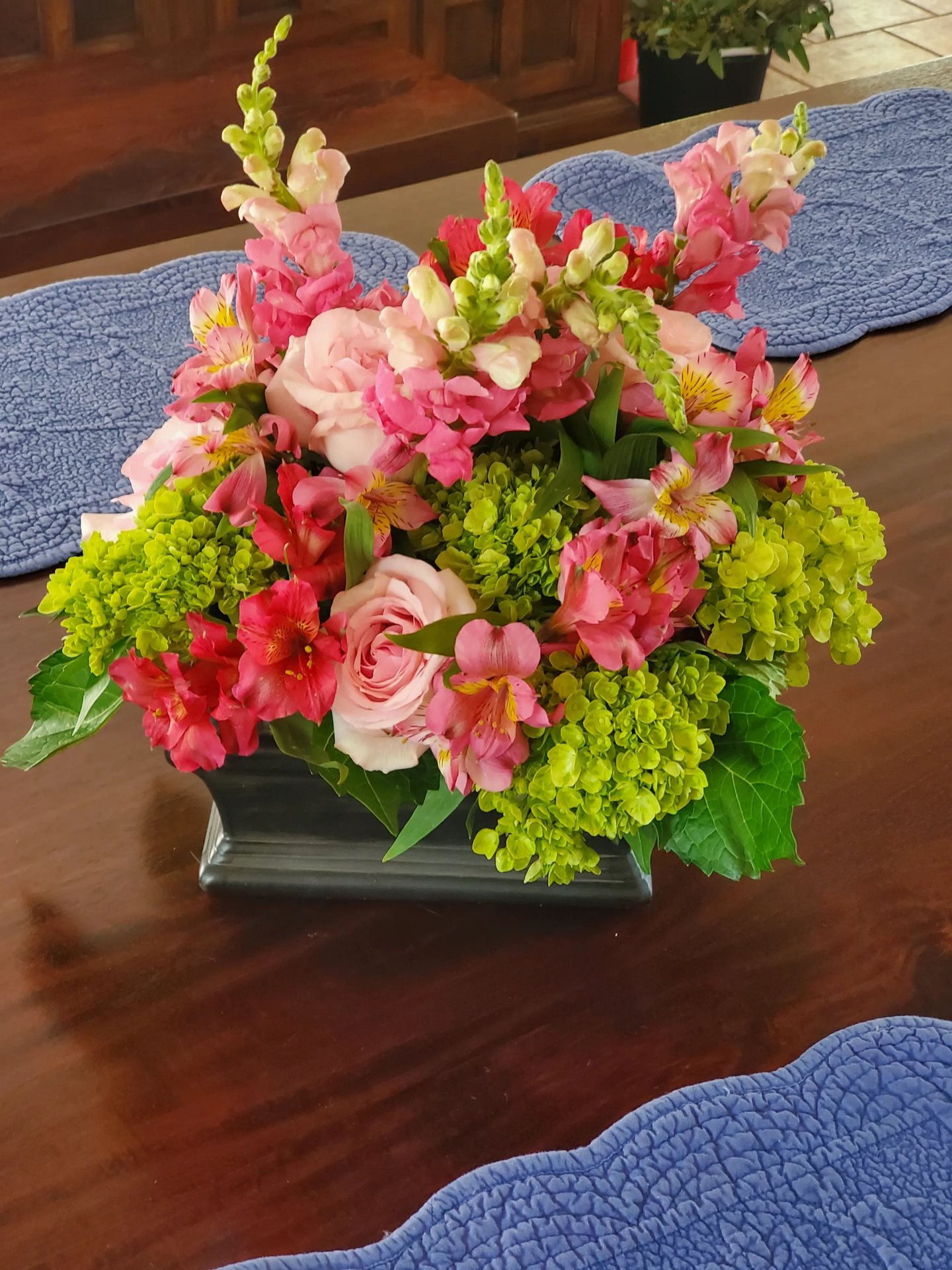 Pink hydrangea, snapdragon, and rose centerpiece on a corporate dining table